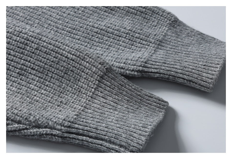 Close-up of ribbed cuffs on the sleeves of a gray knit garment.