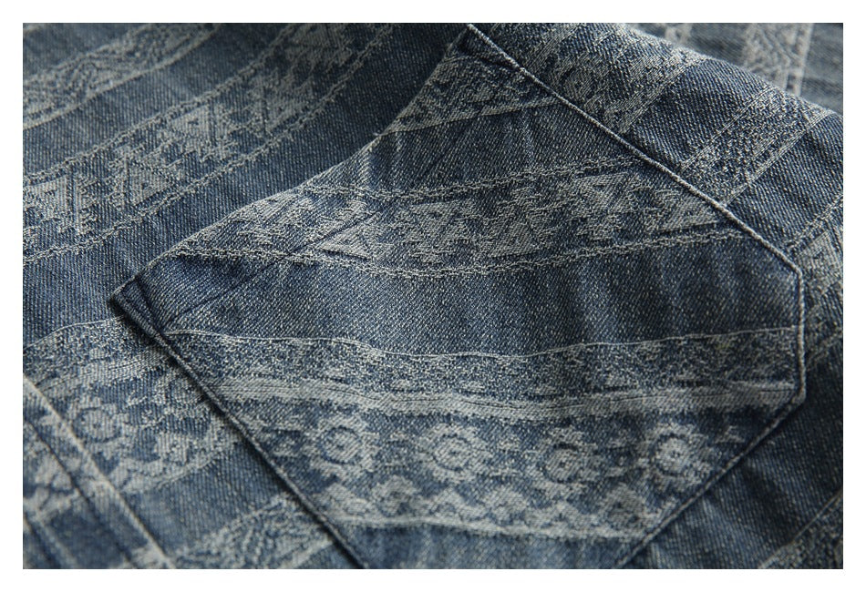 Close-up of a patch pocket on blue patterned denim, showing stitching and geometric bands.