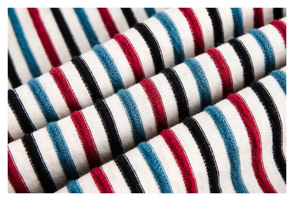 Macro view of white fabric with raised red, teal, and black stripes.