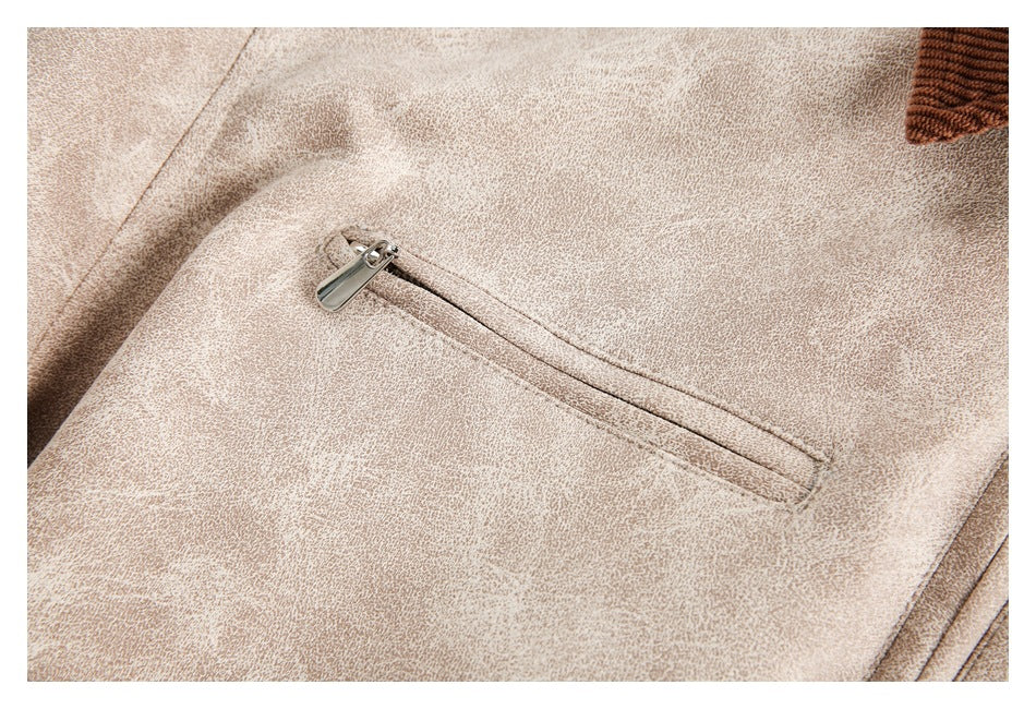 Close-up of a pale beige mottled garment with a diagonal zippered pocket.