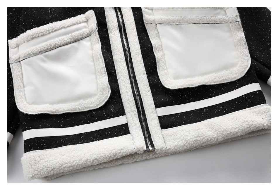 Close-up of a black speckled jacket front with white trim, two large pockets, a center zipper, and a white hem stripe.