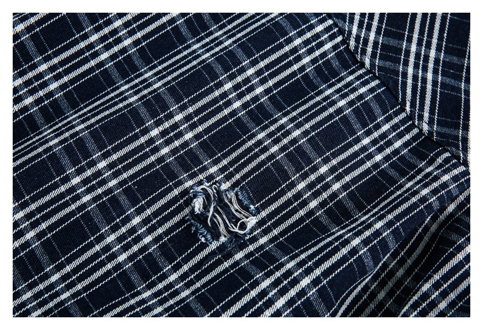 Navy-and-white plaid shirt close-up featuring a small frayed distressed hole.