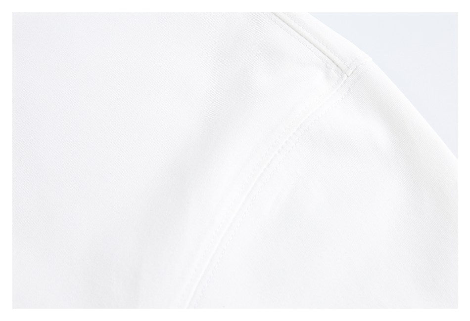 Close-up of the white T-shirt's shoulder seam and knit surface.