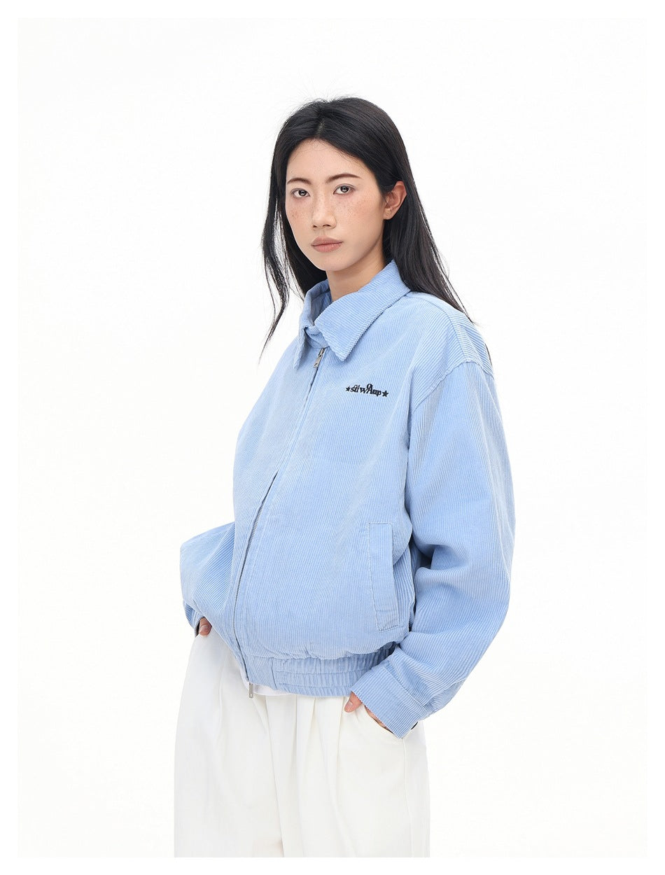 Model wearing a light blue collared zip jacket with elastic hem and cuffs, front pockets, and small black chest lettering.
