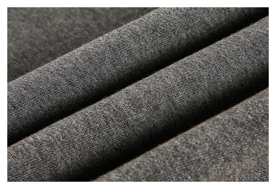 Close-up of folded dark gray knit fabric showing its textured weave.