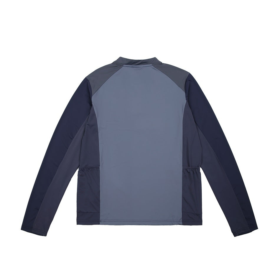 Back view of a slate-blue long-sleeve top with navy sleeves and dark gray shoulder panels.