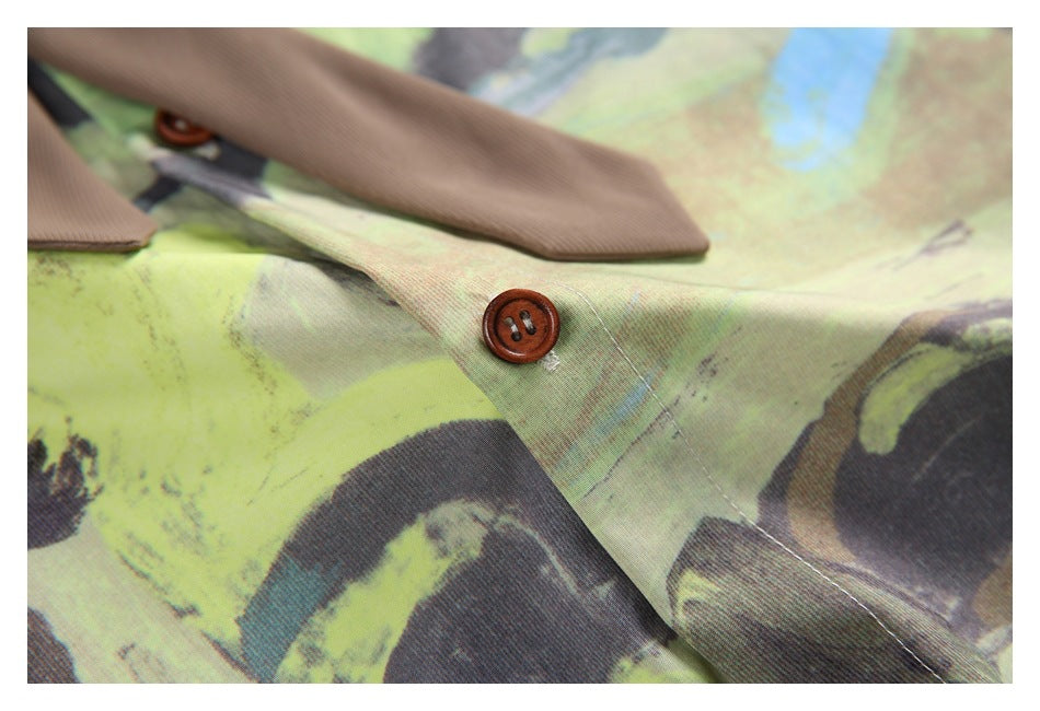 Close-up of a brown button and tie against the shirt's lime, blue, and charcoal abstract print.
