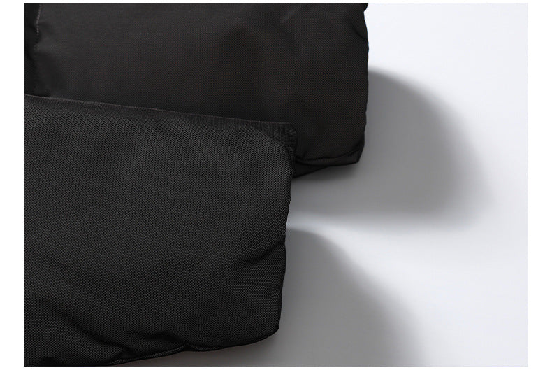 Close-up of a black padded garment edge and stitched seam against a white background.