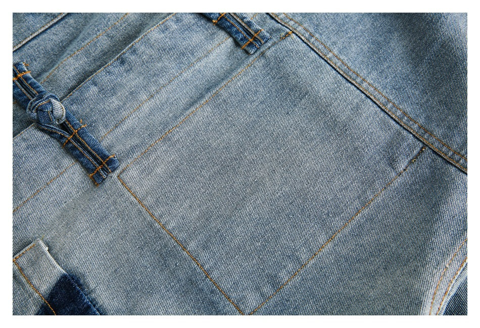 Close-up of faded blue denim panels, orange stitching, and a knotted denim closure.
