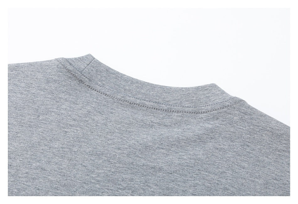 Close-up of the stitched neckline and shoulder area of a heather gray knit garment.