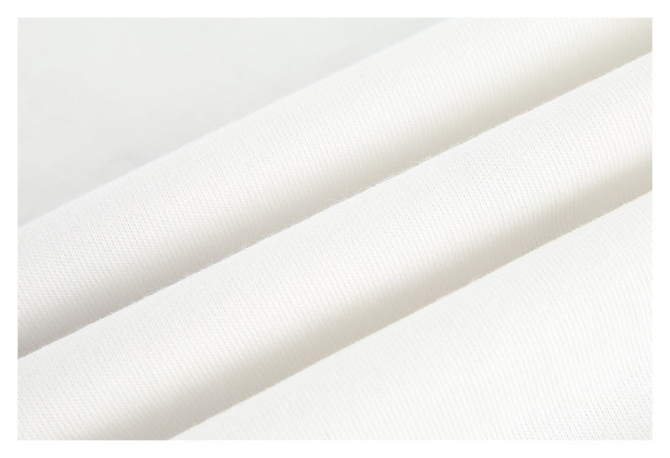 Close-up of white fabric folded into diagonal ridges, showing its surface texture.