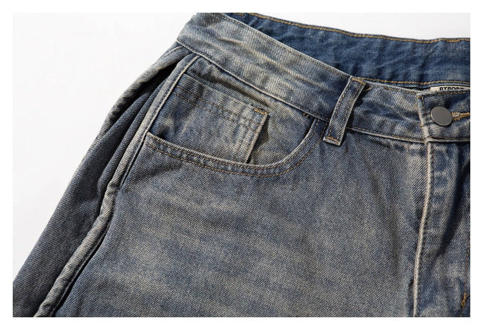 Close-up of a front pocket and small coin pocket on washed gray-blue denim shorts.