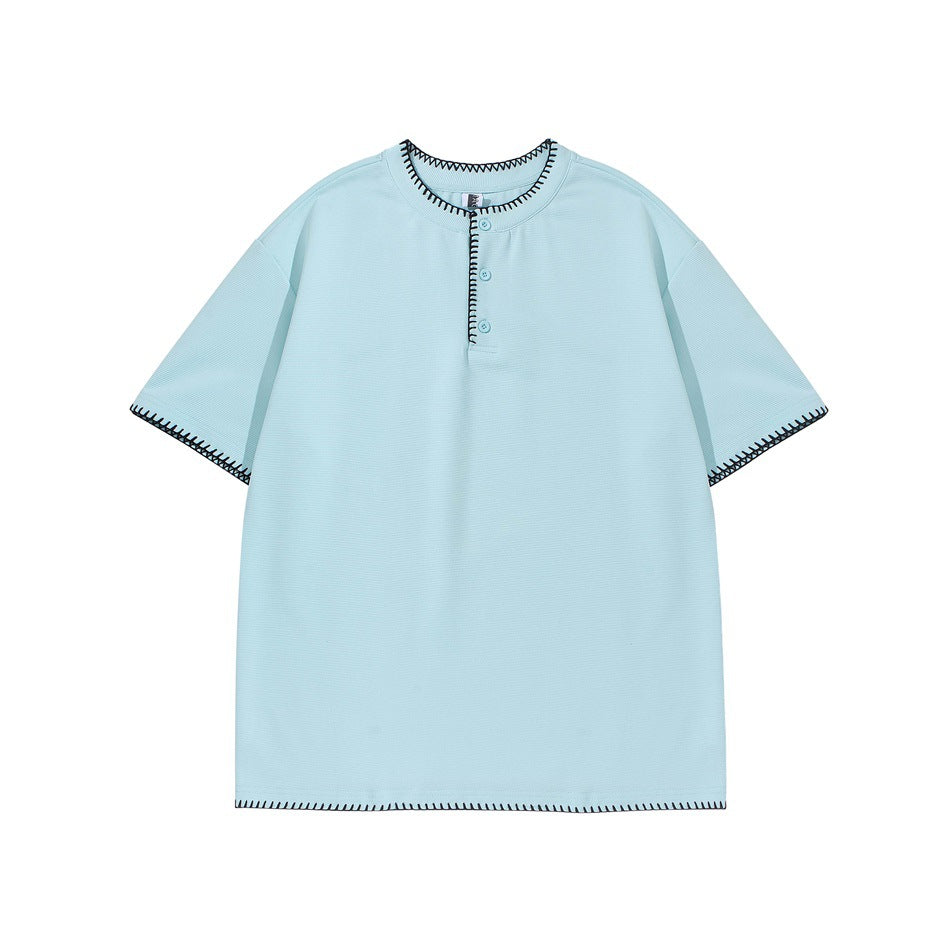 Light blue short-sleeve Henley tee with navy whipstitch trim at neckline, placket, sleeves and hem, flat lay