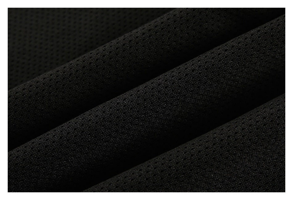 Extreme close-up of folded black mesh fabric showing its perforated texture.