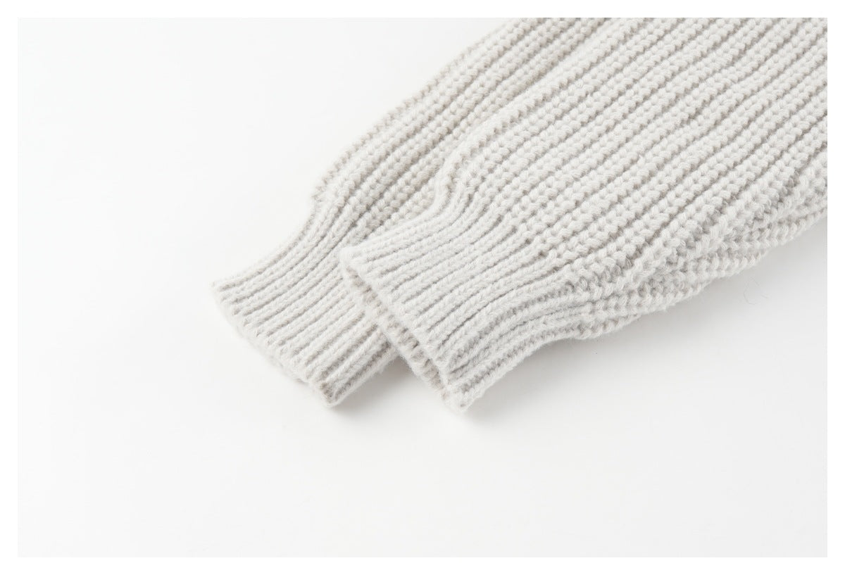 Close-up of the off-white sweater's long ribbed-knit sleeves and fitted cuffs.