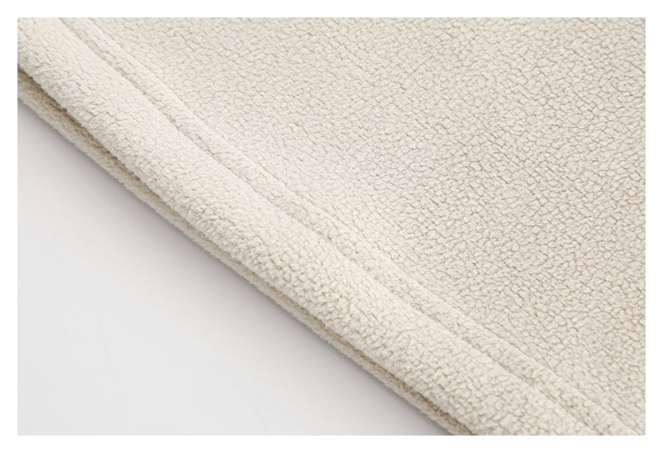 Close-up of the cream textured garment's folded edge and stitched hem.