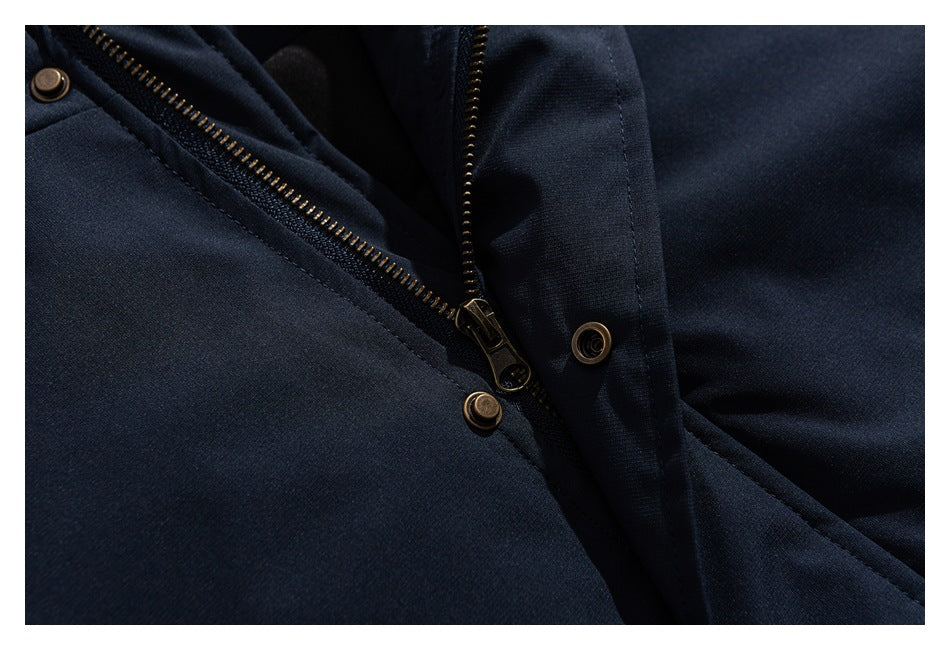 Close-up of a dark navy garment showing a brass-tone zipper and snap fasteners.
