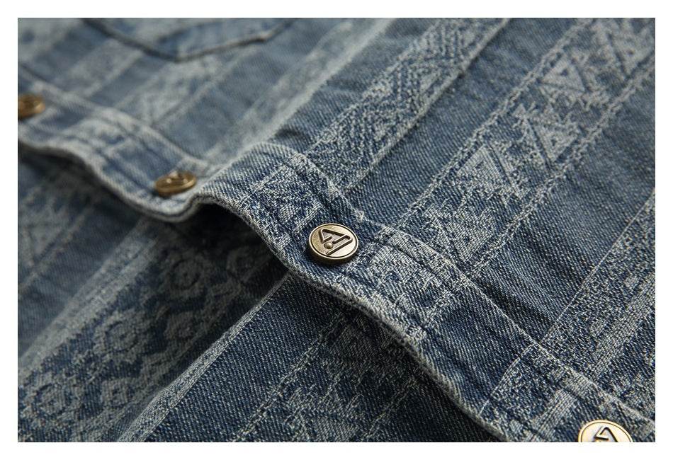 Close-up of brass-tone buttons and stitched placket on blue geometric-patterned denim.