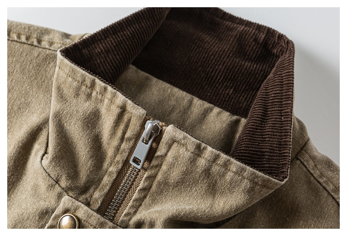Close-up of a tan jacket's dark brown ribbed collar and metal front zipper.