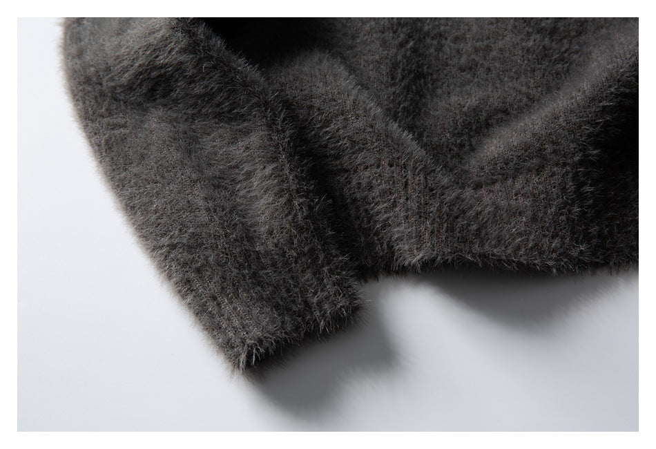 Close-up of a charcoal gray fuzzy knit garment edge and finished cuff.