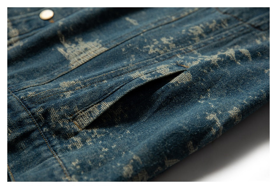 Close-up of a folded section of distressed blue denim showing the fabric pattern, seams, and edge stitching.