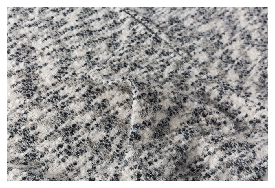 Close-up showing a seam and the fuzzy black-and-white pattern of the garment.