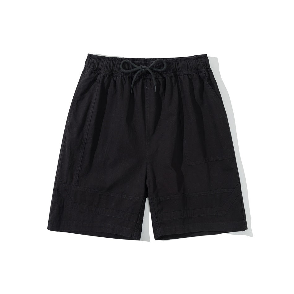 Black knee-length shorts with elastic drawstring waist, patch pocket and stitched hem panels, flat lay front view