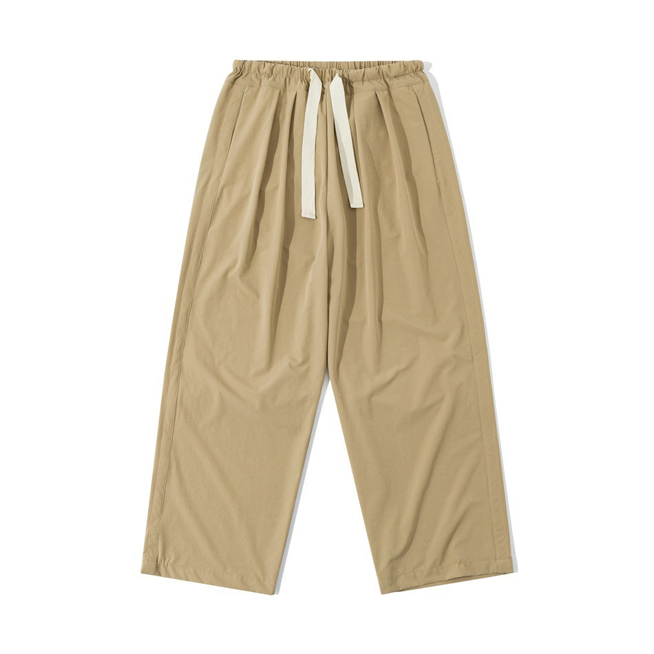 Khaki wide-leg drawstring pants with elastic waistband and front pleats, flat front view