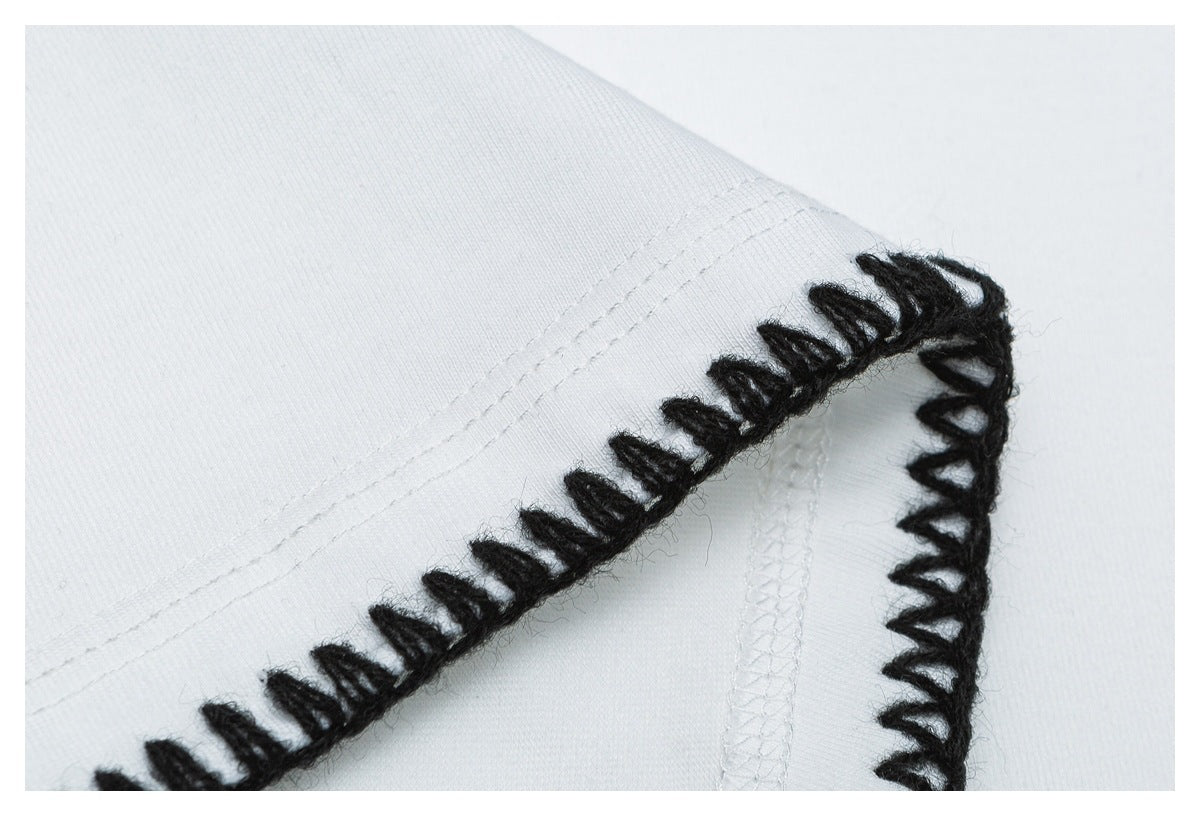 Close-up of a white garment seam finished with prominent black loop stitching.