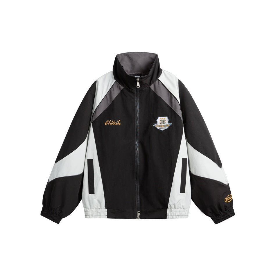 Black zip-up stand-collar jacket with light gray and dark gray color-block panels and an embroidered chest patch