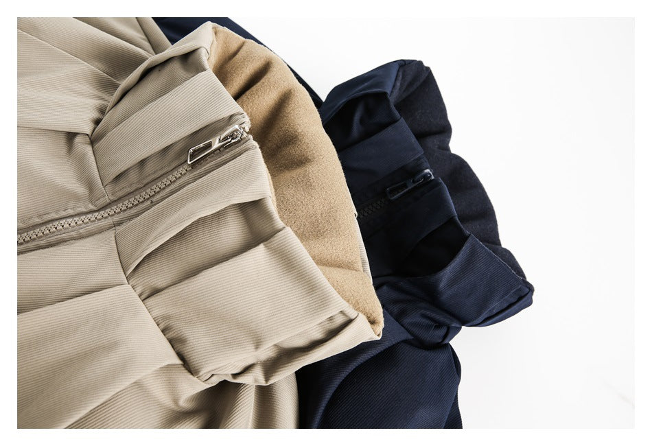 Close-up of beige and navy jackets showing their high collars, zippers and folded construction.