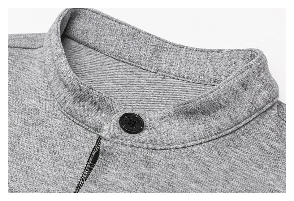Close-up of a heather-gray shirt’s stand collar, top button, stitching, and dark inner trim.