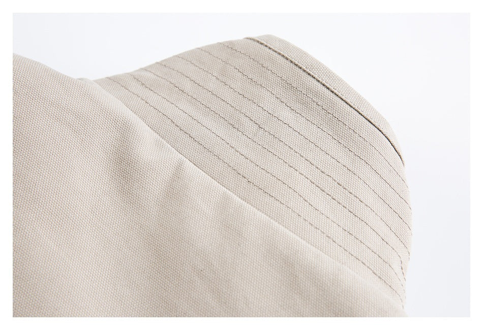 Close-up of a curved, stitched panel on a beige garment.