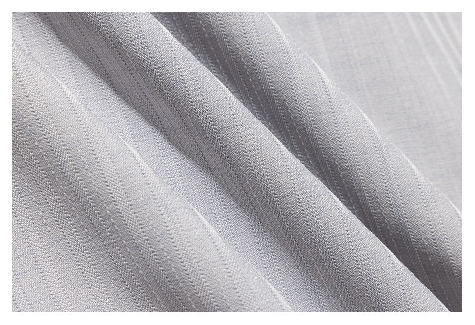 Macro view of textured light gray fabric with subtle narrow stripes and folds.