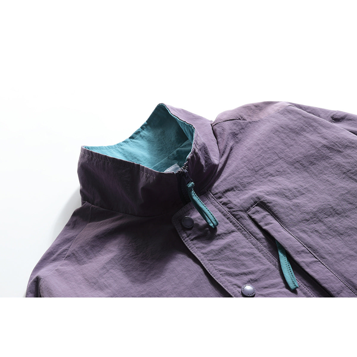 Close-up of a plum jacket collar with teal lining, zipper pull, snap buttons, and front placket.