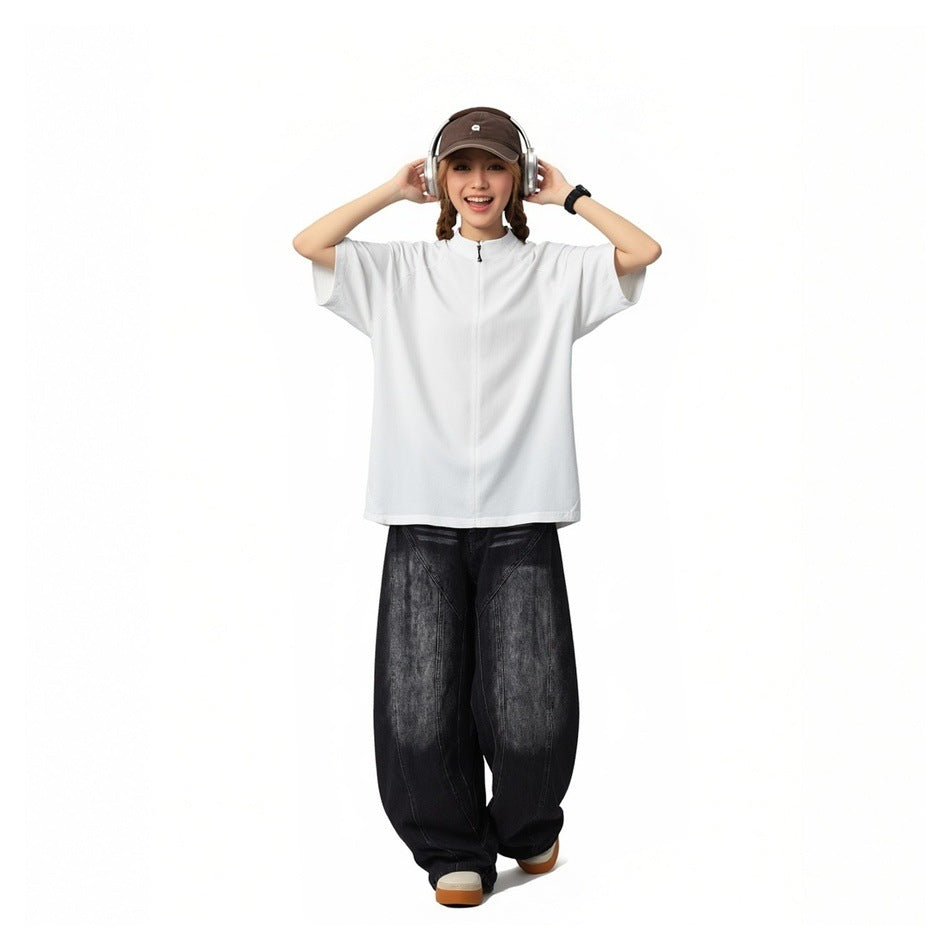 Model wearing washed black wide-leg jeans with curved panel seams and a white short-sleeve zip-neck top.