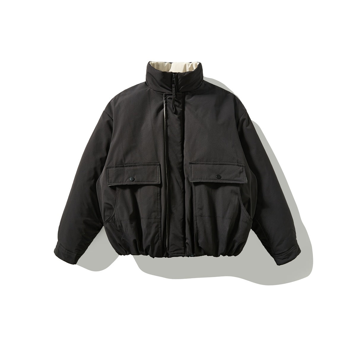 Black zip-front jacket flat lay with two snap-flap chest pockets, gathered hem and cream inner collar