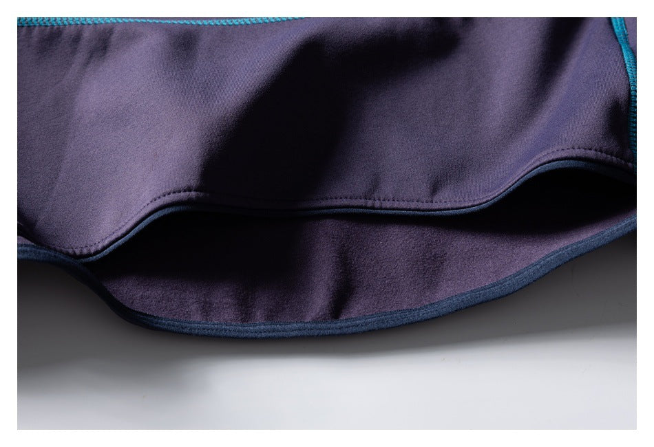 Close-up of the purple top's curved hem, showing the stitching and darker inner layer.