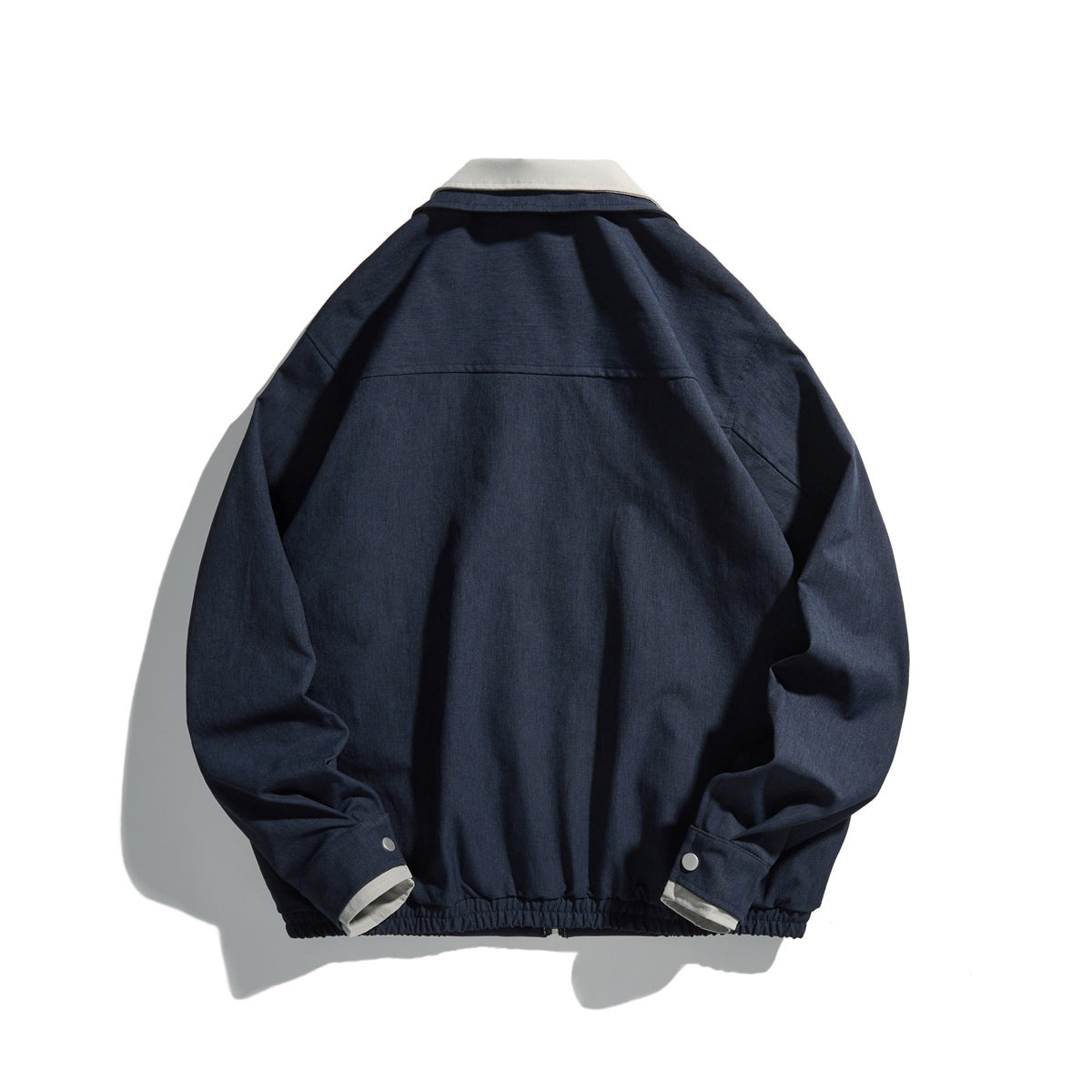 Back view of a navy jacket with a light collar, snap cuffs, and an elasticized hem.