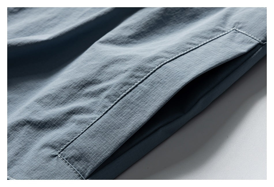 Close-up of a stitched hem on light blue fabric.