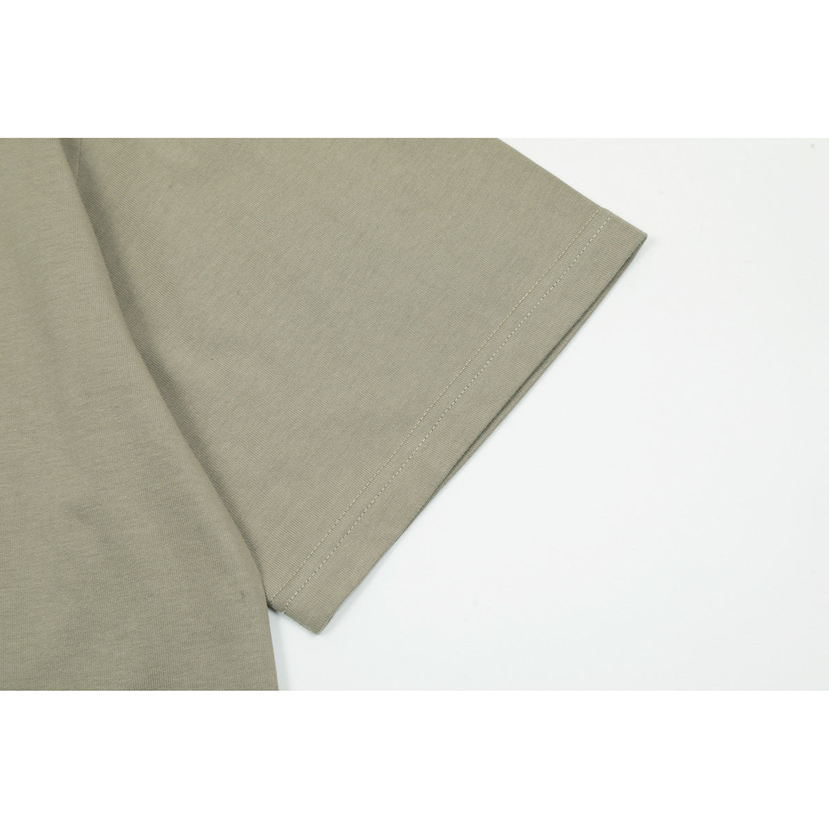 Close-up of the double-stitched sleeve hem on an olive-gray T-shirt.