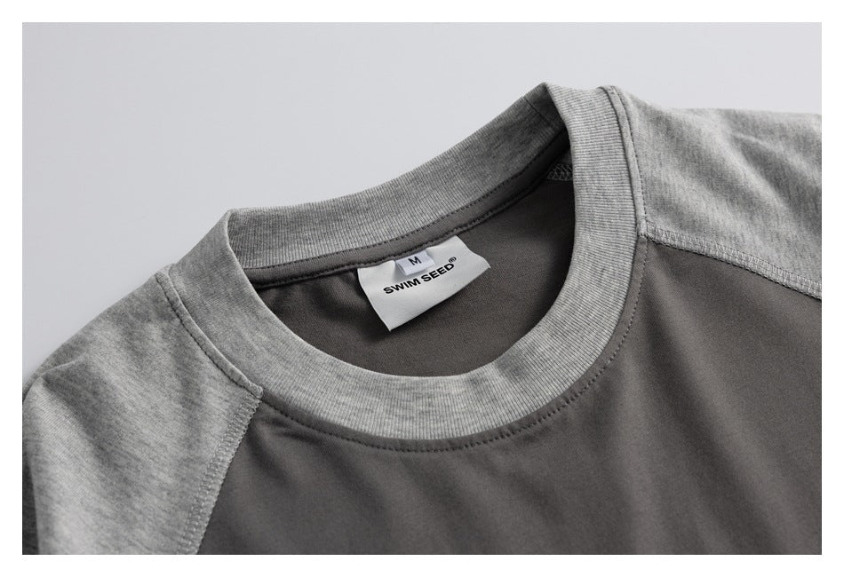 Close-up of the charcoal T-shirt neckline with a ribbed heather-gray collar and a sewn size M label.