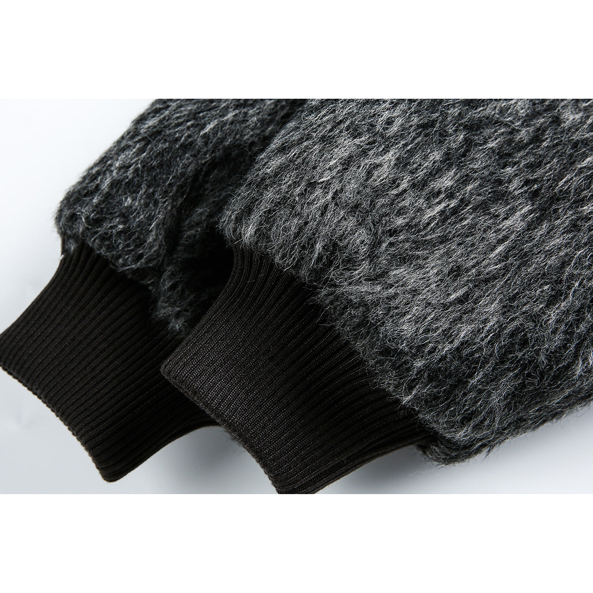Close-up of two black ribbed cuffs on a charcoal gray fuzzy jacket.