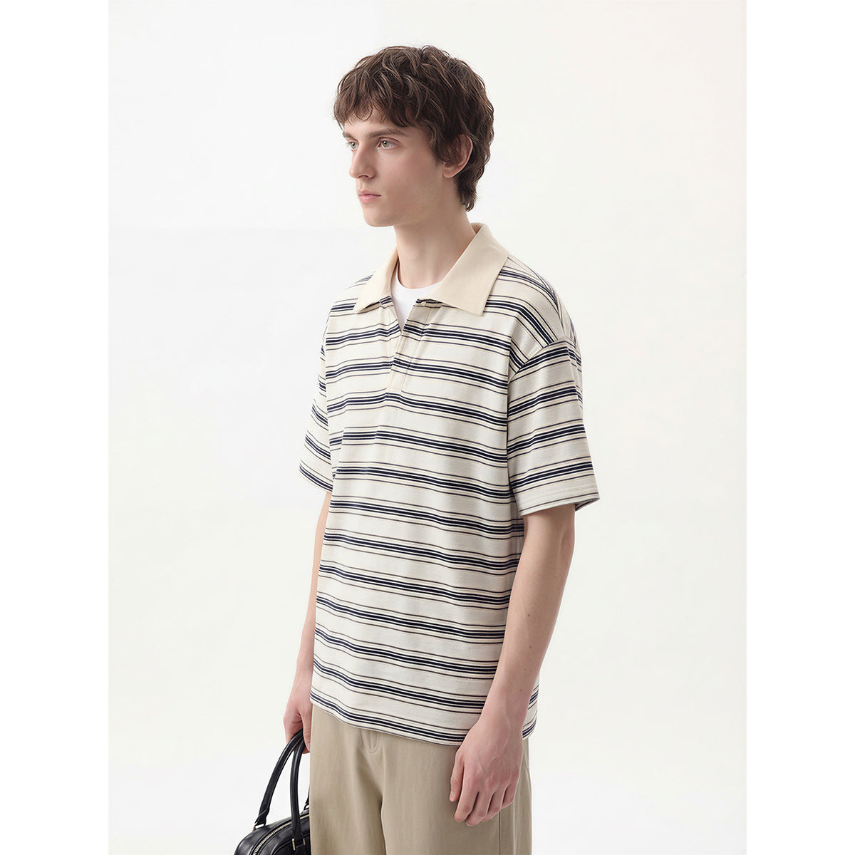 Model wearing an ivory polo with thin navy horizontal stripes and a beige collar.