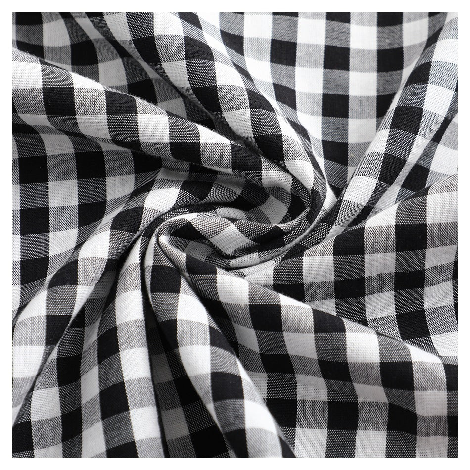 Close-up of black-and-white gingham fabric gathered into folds, showing its woven check pattern.