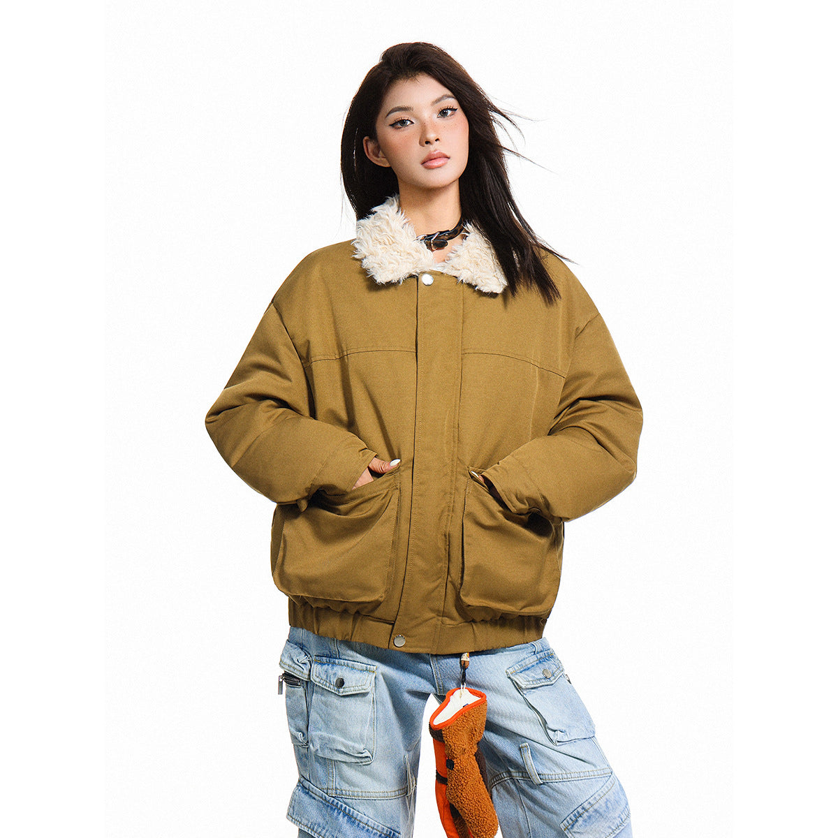 Model wearing an ochre-brown jacket with a cream faux-fur collar, large front pockets and light-wash cargo jeans.