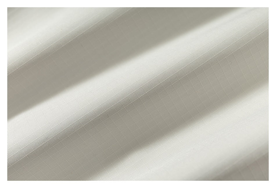Close-up of cream fabric showing its fine grid-like weave and subtle texture.