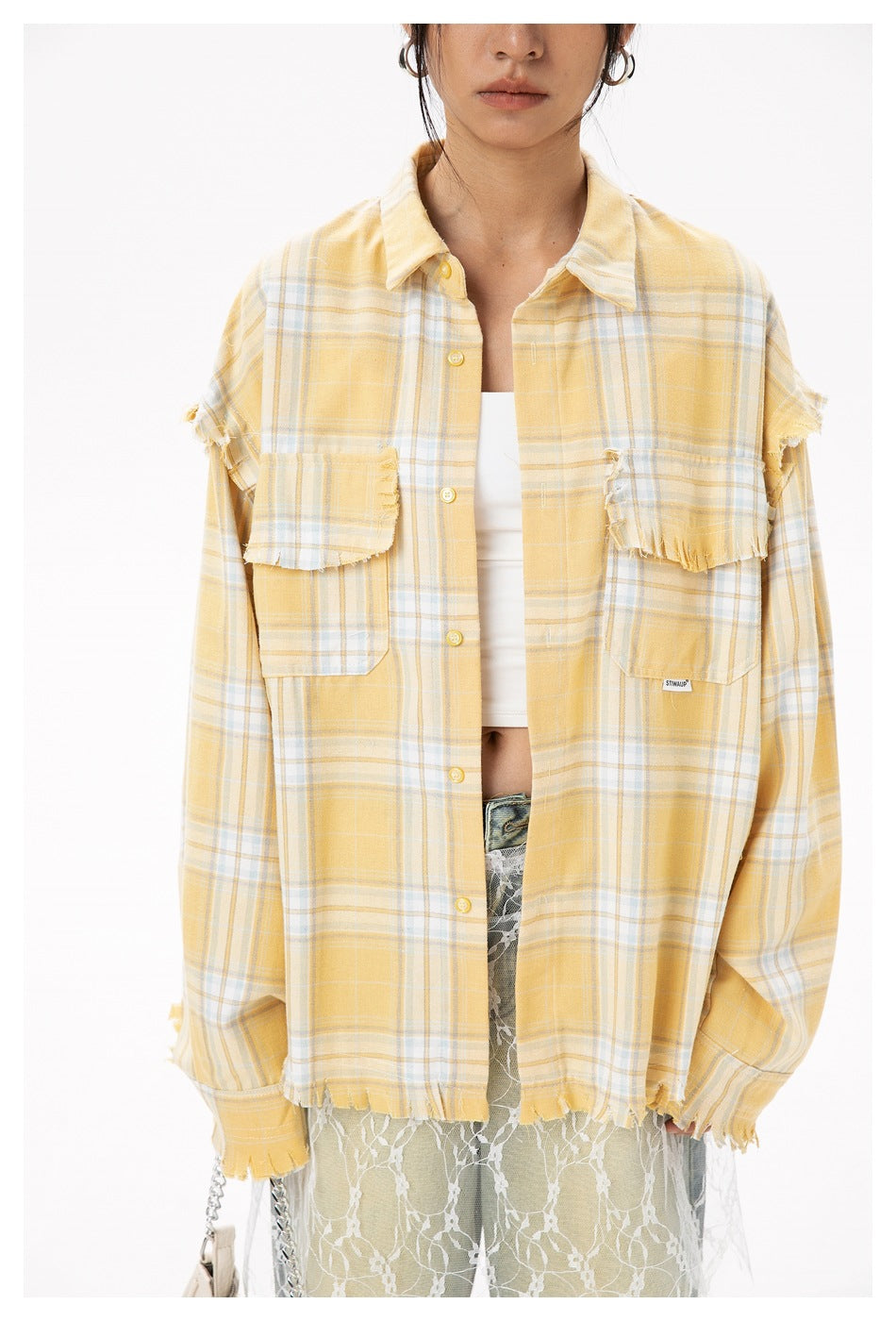 Model wearing a yellow and white plaid button-up shirt with frayed edges and two chest pockets.