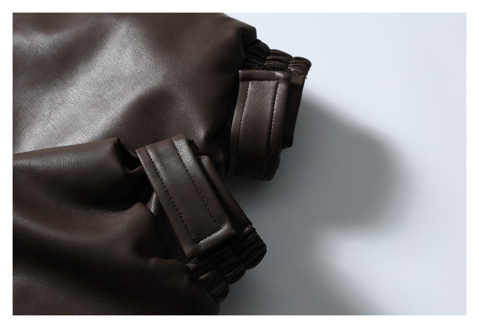 Close-up of a dark brown jacket sleeve cuff with a wide tab and gathered elastic edge.