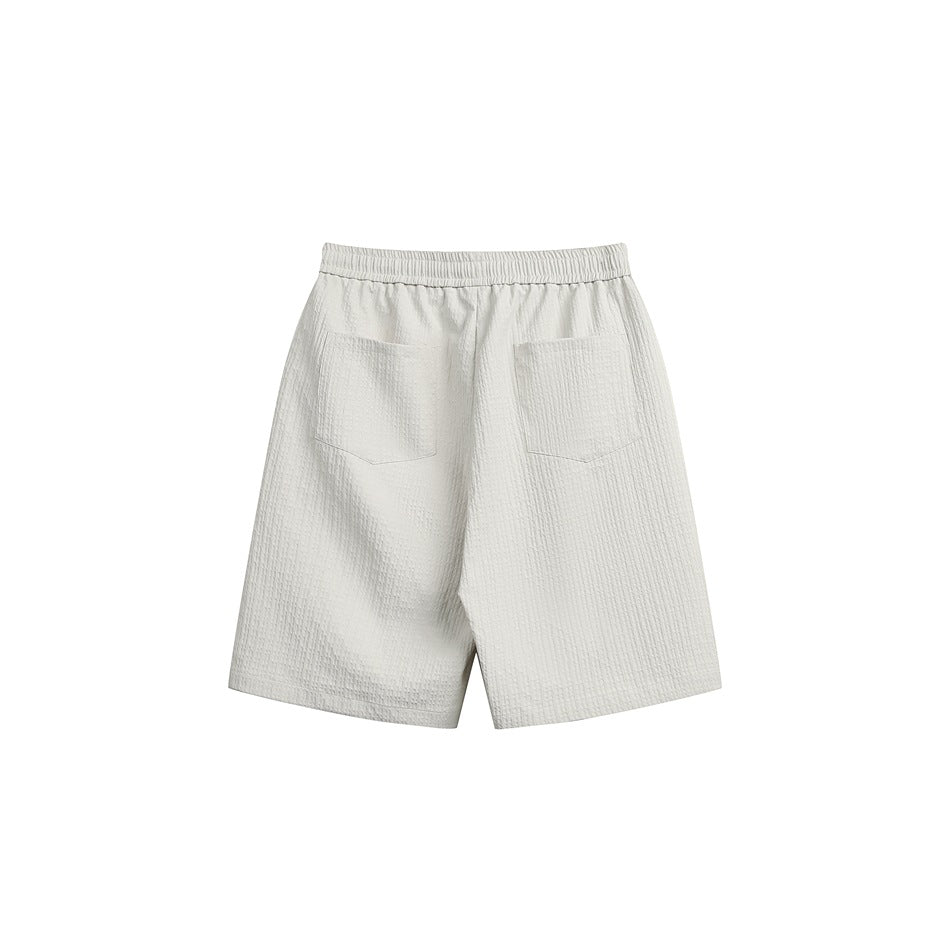 Back view of pale gray shorts with an elastic waistband and two patch pockets.
